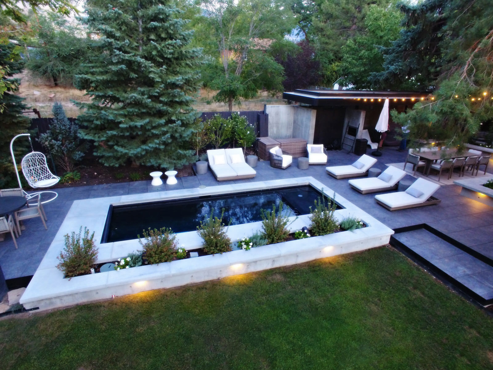 Long and thin outdoor swimming pool surrounded by outdoor living area - Precision Pools